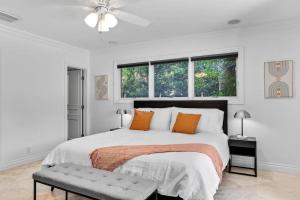 1 dormitorio blanco con 1 cama grande con almohadas de color naranja en Luxury 3 Bedroom Home 5 minutes to Ocean with Heated Pool, en Hollywood 23 fotos más