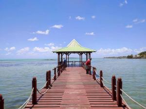 a wooden pier with a gazebo on the water at Ecozy studio in Mahébourg