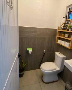 a bathroom with a toilet and a sink at Ecozy studio in Mahébourg