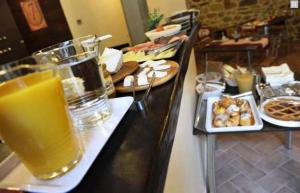 a breakfast bar with a glass of orange juice and food at Bed & Breakfast Viziottavo in Castiglion Fiorentino