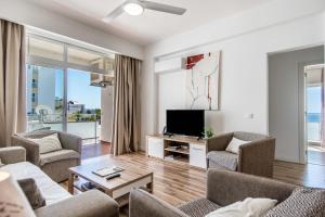 sala de estar con sofá, sillas y TV en Vistamar Apartments en Portimão