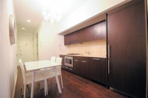 eine Küche mit einem Tisch und eine Küche mit braunen Schränken in der Unterkunft 2 BR in Wall Street in New York