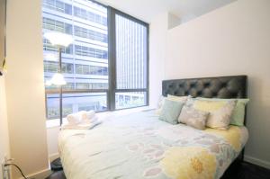 Schlafzimmer mit einem Bett und einem großen Fenster in der Unterkunft 2 BR in Wall Street in New York