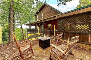 a backyard with two chairs and a house at King Beds, VIEWS, Fire Pit, Spa, No Fees, New, Private, Games in Sevierville