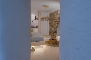 a bedroom with a bed and a stone wall at Cave Dame in Mési +11 photos