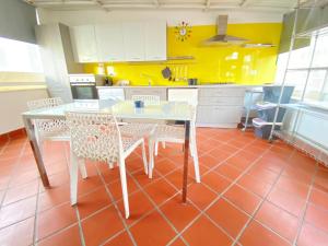 a kitchen with a table and chairs and yellow walls at Attico Solimena - Private Terrace cityview in Naples