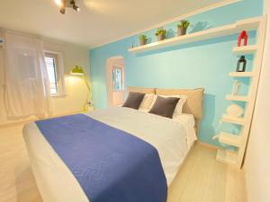a bedroom with a bed with a blue wall at Attico Solimena - Private Terrace cityview in Naples