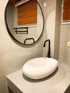 a bathroom with a white sink and a mirror at Ace Tiny Home in Alaminos - Home of the Hundred Islands in Alaminos