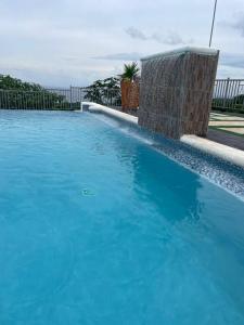 a large blue swimming pool in a yard at Catch a Vibes Bolt! - Ocho Rios in Ocho Rios