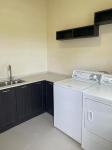 a kitchen with a white refrigerator and a sink at Catch a Vibes Bolt! - Ocho Rios in Ocho Rios