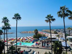a view of a beach with a pool and palm trees at Brezza di Mare in Imperia