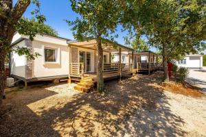 a row of mobile homes in a yard with trees at Mini camping FUNTANA in Poreč