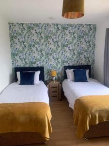 dos camas sentadas una al lado de la otra en un dormitorio en Moray View, Macduff, Aberdeenshire., en Macduff