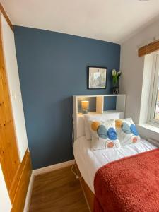 a bedroom with a blue accent wall and a bed at Birch Avenue House, entire house with 4 bedrooms, free parking, free WI-FI, Smart TV, washing machine, easy access to M1 in Ilkeston