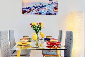 a dining room with a table with chairs and flowers on it at Super-Quiet Town Centre Flat 5 min Walk to Station in Royal Tunbridge Wells