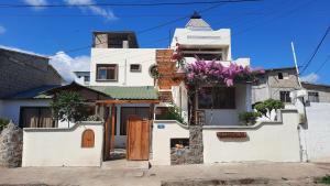 uma casa branca com flores ao lado dela em Alma de cedrela em Puerto Ayora