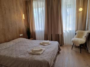 Un dormitorio con una cama y una silla y una ventana. en Apartma Larisa, en Bled
