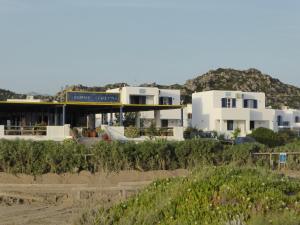 a building on the beach with mountains in the background at Aronis Plaka Naxos in Plaka