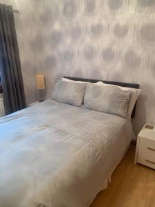 Una cama con sábanas blancas y almohadas en un dormitorio en Moray View, Macduff, Aberdeenshire., en Macduff