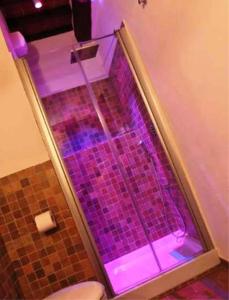 y baño con ducha con luces moradas. en Bed & Breakfast Viziottavo, en Castiglion Fiorentino