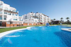 uma piscina em frente a alguns edifícios de apartamentos em Pierre & Vacances Almeria Roquetas de Mar em Roquetas de Mar