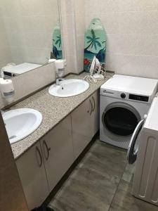 a bathroom with two sinks and a washing machine at Your Home Hotel in Tbilisi City