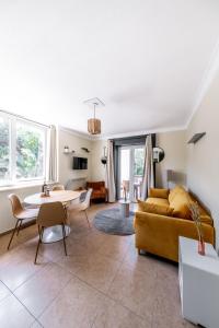 ein Wohnzimmer mit einem Sofa und einem Tisch in der Unterkunft Résidence Chateau d'Acotz - Appartements avec piscine à 600m des plages à Saint-Jean-de-Luz in Saint-Jean-de-Luz