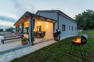 een achtertuin met een barbecue en een huis bij Bibali in Buje