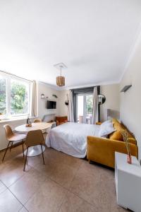 een slaapkamer met een bed en een tafel en stoelen bij Résidence Chateau d'Acotz - Appartements avec piscine à 600m des plages à Saint-Jean-de-Luz in Saint-Jean-de-Luz