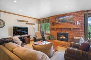 ein Wohnzimmer mit einem Sofa und einem Kamin in der Unterkunft Bear Claw 413 - Bear Claw II Building in Steamboat Springs