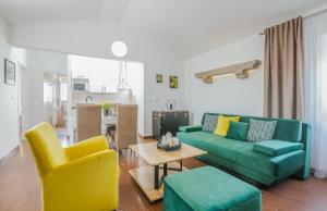 ein Wohnzimmer mit einer grünen Couch und gelben Stühlen in der Unterkunft Apartment Marina in Malinska + 29 Fotos