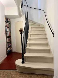 eine Treppe in einem Wohnzimmer mit Bücherregal in der Unterkunft La petite maison aux volets bleu - Montpellier in Montpellier