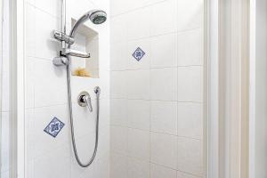 a bathroom with a shower with blue tiles at Clelia Apartments in Parma
