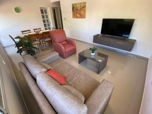 sala de estar con sofá y TV en Cálido y Amplio Dpto Céntrico 1D en Formosa