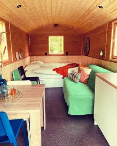 1 dormitorio con sofá y 1 cama en una habitación en Pipowagens bij Pannenkoekenrestaurant & Camping De Koppenjan 'Een uniek verblijf met kinderspeelboerderij', en Jubbega-Schurega