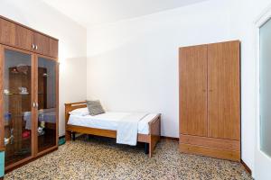 帕爾馬的住宿－Clelia Apartments，一间卧室配有一张床和一个木制橱柜