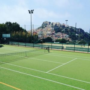 a person is playing tennis on a tennis court at Casa Giuseppe Castelsardo in Castelsardo