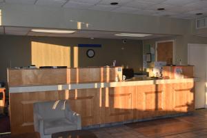 a kitchen with a counter with a clock on the wall at Super 8 by Wyndham Riverside AL in Riverside