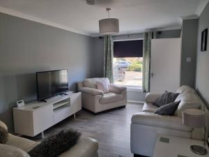 a living room with two couches and a flat screen tv at Oldwood Home from Home 3 in Livingston