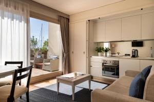a living room with a couch and a table and a kitchen at Marina di Scarlino Resort in Puntone di Scarlino