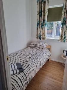 a small bed in a room with a window at Oldwood Home from Home 3 in Livingston