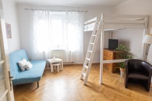 a living room with a bunk bed and a blue couch at Apartmán U Šálků in Znojmo