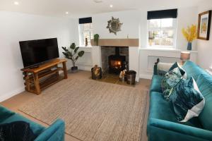 a living room with a blue couch and a fireplace at Central Ripon apartment - view of the Cathedral! in Ripon