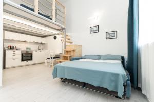 a white bedroom with a bed and a kitchen at Sea Loft Quinto - A due passi dal mare in Genoa