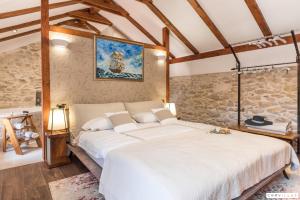 a large bed in a room with a stone wall at Ij Dvori in Skradin +42 photos