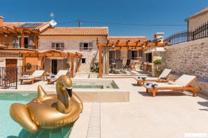 a pool with a gold inflatable animal in a house at Ij Dvori in Skradin
