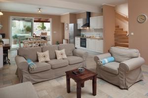a living room with a couch and chairs and a kitchen at Kate in Podgora