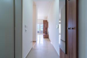 um corredor de uma casa com paredes brancas e pisos brancos em Apartmani na Plaži em Risan