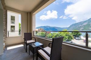 a balcony with chairs and a large window with a view at Apartmani na Plaži in Risan