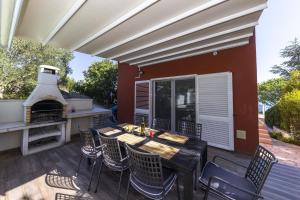 a patio with a table and chairs and a fireplace at Karmen Adriatica in Kukljica